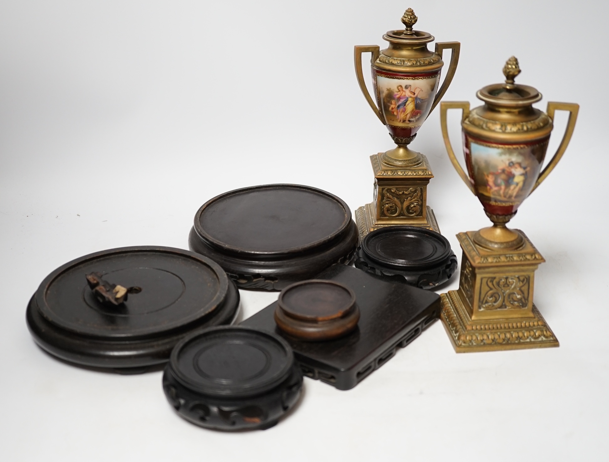 A pair of Vienna style brass mounted urns with enamelled classical scenes and six various Chinese carved hardwood stands, 23cm high